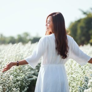 Portrait image of an asian woman walking into a beautiful Cutter flower field